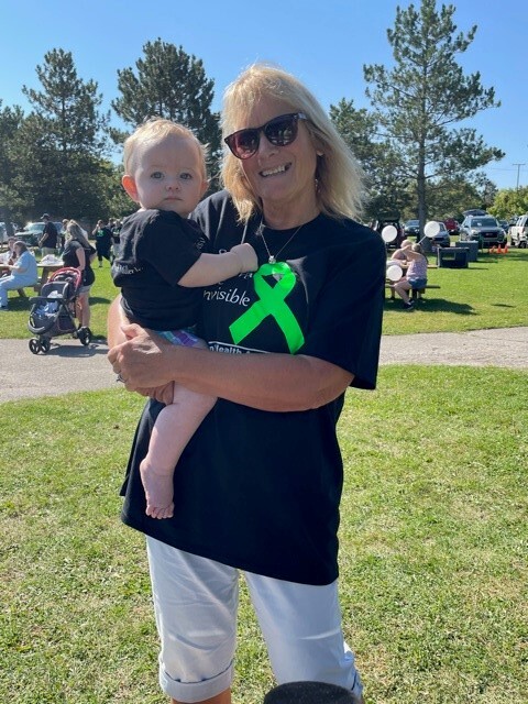 Peggy Desotell holds Everly Jones, 10 months old, at the Into the Light Suicide Awareness Walk at Rowden Park in Lapeer.